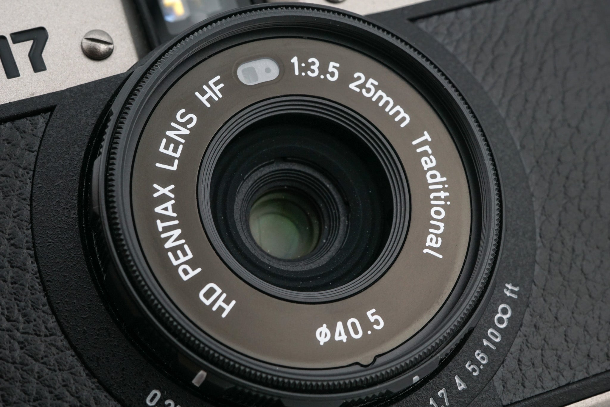 A close-up of Pentax 17 half-frame camera lens on a white background.